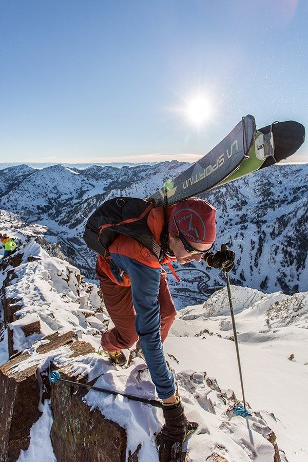 Jason Dorais trekking uphill with skis