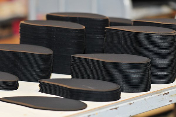 Rubber soles, sorted by size, are prepped for final assembly
