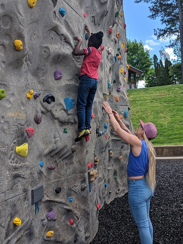 Emily Harrington spotting a kid at the Intro to Rick Climbing class
