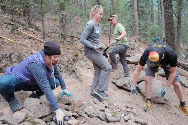 La Sportiva North America staff member Ryan Ward builds rock walls along the trail