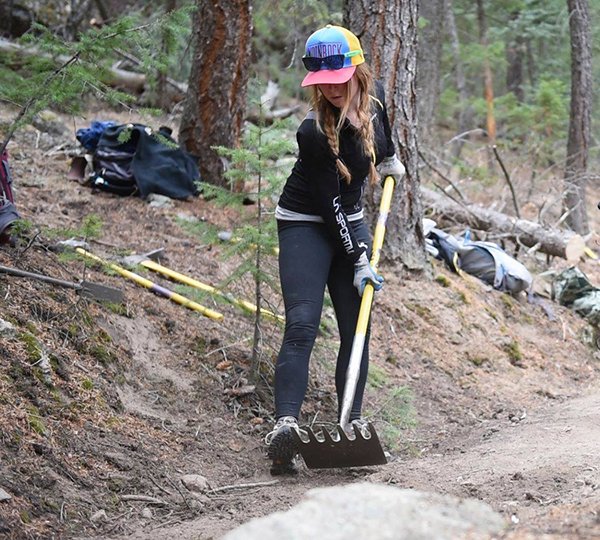 La Sportiva North America staff member Hillary Sugg levels out the trail at the Conservation Alliance Backyard Collective trail work day at Dedisee Park in Evergreen, Colorado